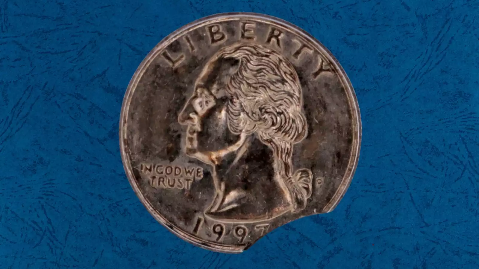 1997 quarter clipped planchet error showing a curved crescent-shaped bite missing from the coin edge